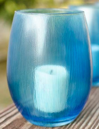 Blue votive candle holder with white candle.